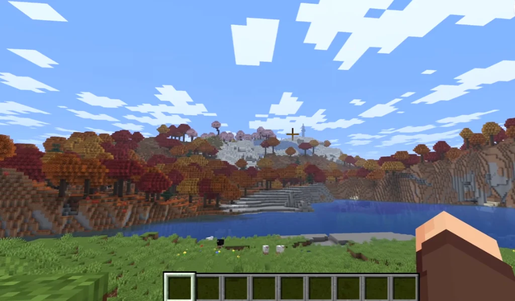 First-person view from spawn looking across the water toward the Dappled Forest hills with snow slopes and pink Cherry Groves in the distance